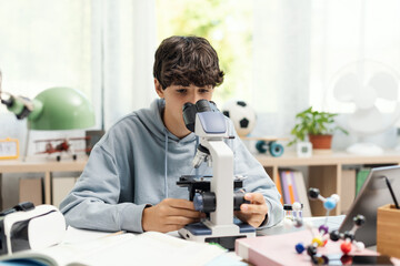 Young student using a microscope