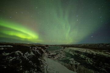 Northern lights in Gullfoss area in winter with ice in Iceland