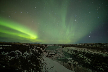 Northern lights in Gullfoss area in winter with ice in Iceland