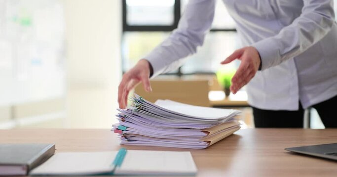 Female manager puts stack of office documents on table