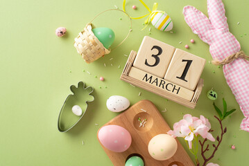 Easter-ready top view flat lay: Colorful eggs, adorable bunny decor, baking cookie cutter, wooden date cubes, apple blossoms, sugar sprinkles on pastel green background. Ideal for Easter preparations