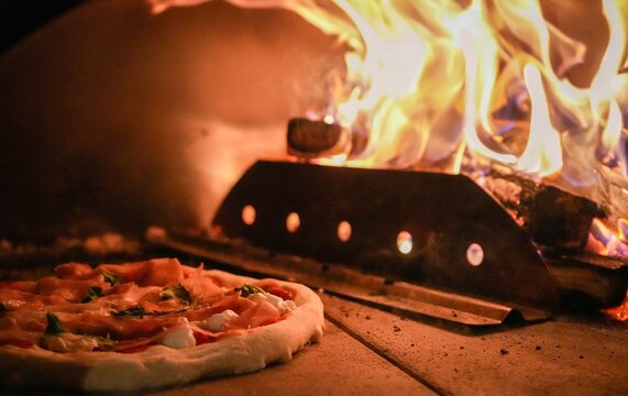 Homemade Pizza Cooking in Wood-Fired Oven - Outdoor Pizza Oven 