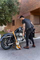 Hipster guitarist with his motorcycle. Rock aesthetic.