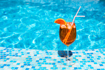 Glass of alcohol cocktail near the pool