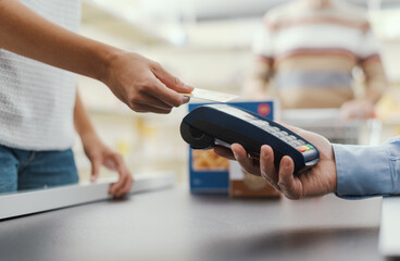 Woman paying with a credit card at the supermarket