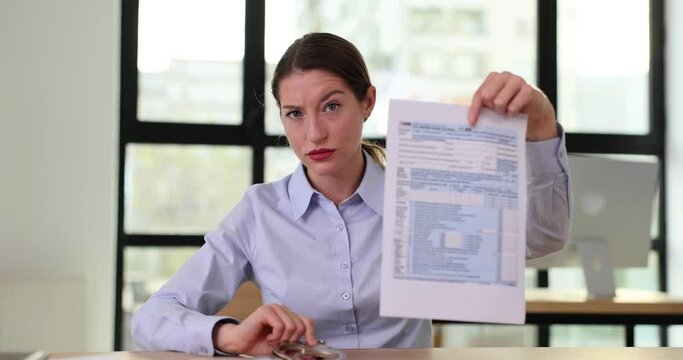 Strict businesswoman with form 1040 and handcuffs