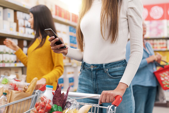 Woman using a smartphone at the supermarket