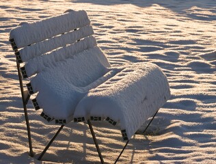 ogrodowa ławka pod śniegiem