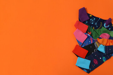 Bright socks with a print, in a pile on an orange background.