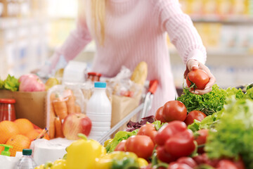 Obraz na płótnie Canvas Woman buying fresh organic vegetables at the supermarket