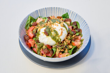 Healthy salad with tomatoes, mozzarella cheese and pesto