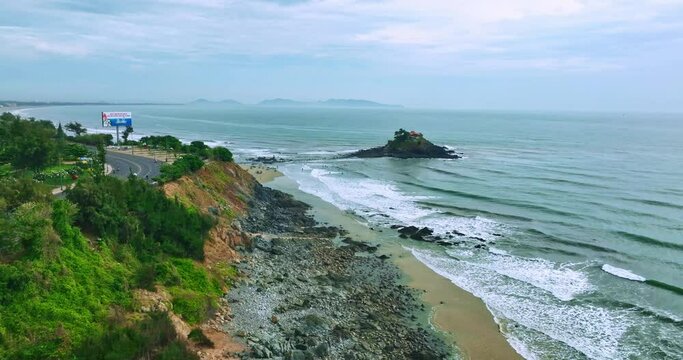 Aerial view of Hon Ba island in Vung Tau city, Vietnam. On full moon day of lunar calendar, when tide is low, people can walk across island to visit temple on mountain. Spiritual travel concept.