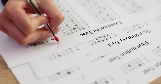 Teacher gives a grade on exam test closeup