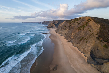 Fototapeta premium Cordoama beach in Portugal. Aerial drone view of waves, sandy beach and cliffs