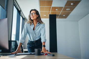 Female professional standing at her desk in an office