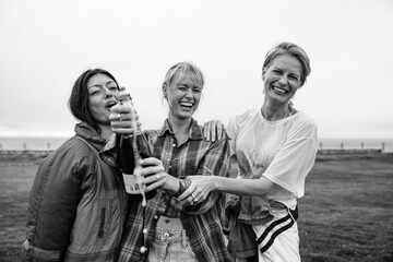 Girlfriends popping a champagne bottle in celebration