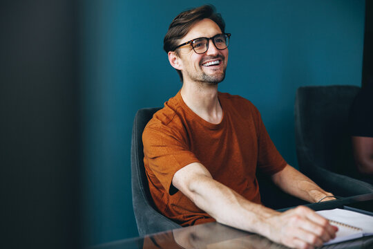 Accomplished business man smiling and sitting in a meeting at work