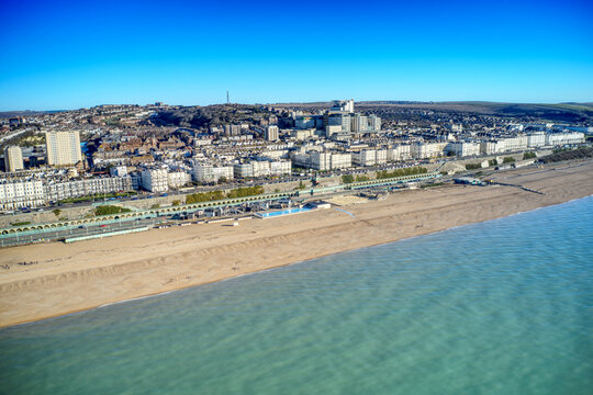Aerial view of Brighton seafront with Victorian buildings along Marine Drive and Madeira Drive with the Volks Electric Railway in the foreground.