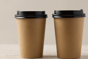 tasty coffee. two cups of coffee, black plastic lids, gray background. invigorating drinks concept