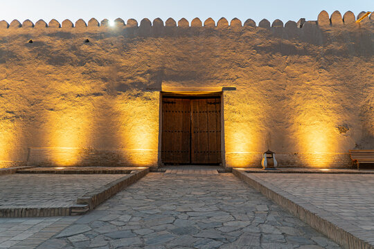 carved wooden door in the wall of a medieval fortification. a carved wooden door in the wall of a medieval fortification. old town Ichan Kala. Khiva, Uzbekistan.