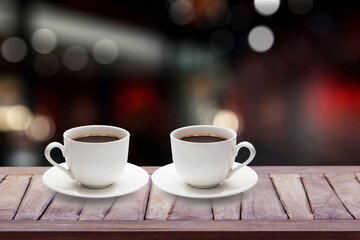 Hot coffee cup on counter in blurry coffee shop background.