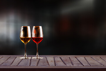 Wooden table with wine glasses and blurred bokeh on a dark background. Cafe-bar,...