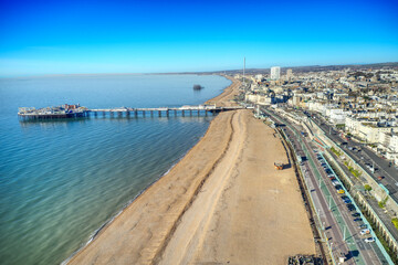 Aerial view along Brighton Beach towards the Victorian Palace Pier, a popular seaside resort in East Sussex England.