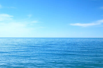Nature blue background with wavy sea ripples on water surface and cloudy sunny sky. Scenery...