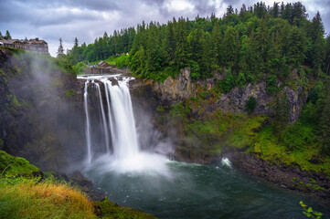 Snoqualmie Falls with lush greenery and mist in Washington State, USA. Snoqualmie Falls is a 268-foot waterfall on the Snoqualmie River between Snoqualmie and Fall City. Long exposure.