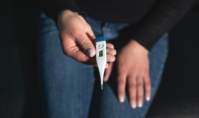 Caucasian young woman showing thermometer.