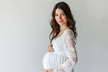 Portrait of beautiful young pregnant woman touching belly standing on colour background