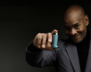 man with respiratory inhaler puff on grey background with people stock image stock photo	