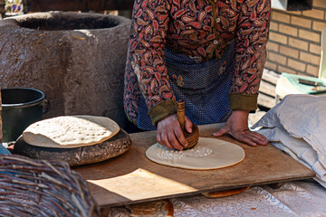 Woman make traditional tandoori bread. Khiva, Uzbekistan.