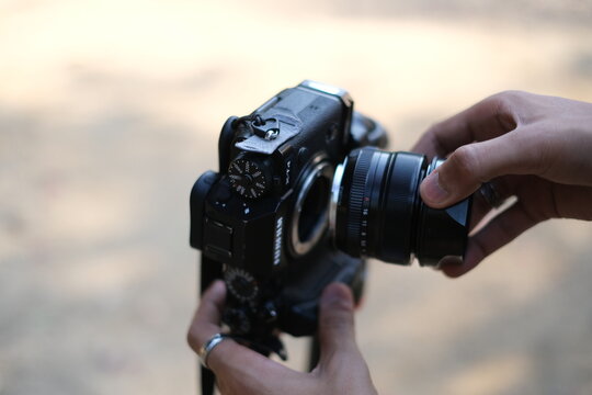 Close up of a camera body with lens held by a person, Street photography : New Delhi India 2024