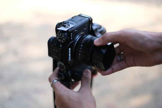 Close up of a camera body with lens held by a person, Street photography : New Delhi India 2024