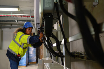 female technician Check the solar inverter panels in the electrical room. Service engineer installs...