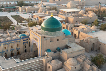 Historical buildings of Khiva Uzbekistan from above. Building with green dome is mausoleum of Pahlavan Mahmoud. Foreground: Mazar-i-Sharif madrasah, ancient mausoleums and tombstones of nobility