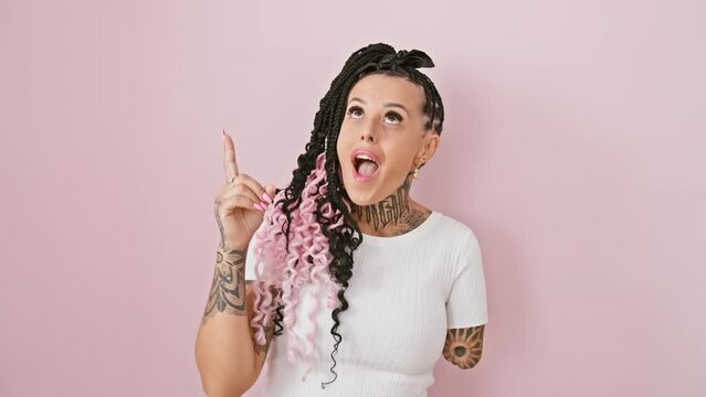 Cheerful hispanic amputee woman standing over isolated pink background. clever face, pointing one finger up with a smart idea, expressing happiness, success, and thinking number 1.