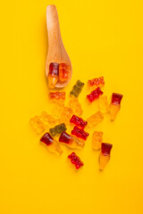 jelly bears candy and spoon wooden isolated on a yellow background. Jelly Bean.