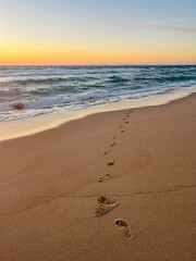 Warm colors of the seascape, sand sea coastline, sea waves on the sand, clear blue sky, no people, empty beach
