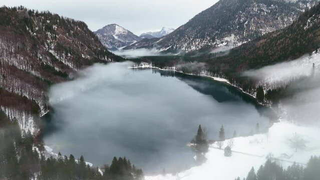 Drohnenflug &uuml;ber dem See in den Bergen in sch&ouml;ner Landschaft im Winter im Salzkammergut