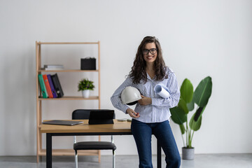 Young female architect working with home drawing plan on blue print with architect equipment in the office