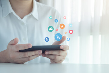 Person using mobile phone with notification icons of email, contact, shopping online, love and star above smartphone screen. Technology, Communication and Social media content marketing concept.