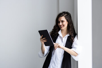 Young happy businesswoman working with tablet in corporate office