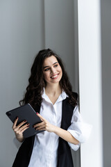 Young happy businesswoman working with tablet in corporate office