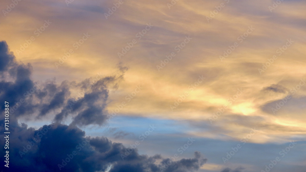 Wall mural clouds at sunset. the sky is painted with bright colors by the rays of the setting sun. the rays of 