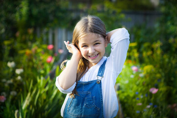 Portrait of happy smiling little girl in sunny garden