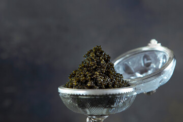 Black caviar. Caviar in a vintage caviar bowl. Natural omega. An exquisite snack. Copy space.
