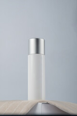 Plastic white tube for cream or lotion. Skin care or sunscreen cosmetic with stylish props on white background 