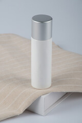 Plastic white tube for cream or lotion. Skin care or sunscreen cosmetic with stylish props on white background 